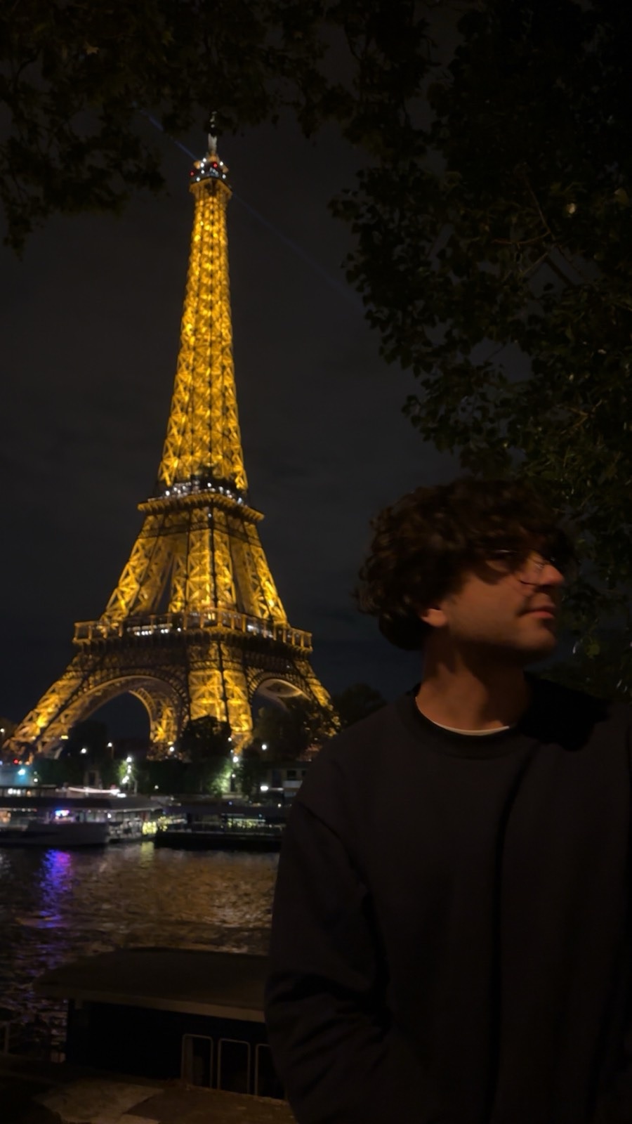 Iyad Mallah beside the Eiffel Tower at night in Paris